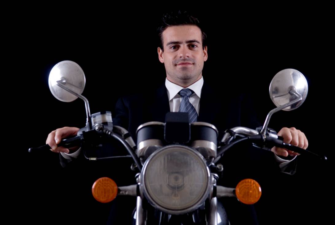 A person in a suit and tie holding a motorcycle
AI-generated content may be incorrect.